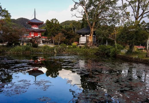 The vermilion Shingyo Hoto pagoda of Daikaku-ji reflected in a pond in Kyoto