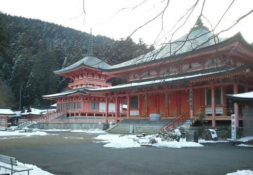 Vermilion halls and a two-storey pagoda of Enryaku-ji on Mount Hiei, with snow on the ground