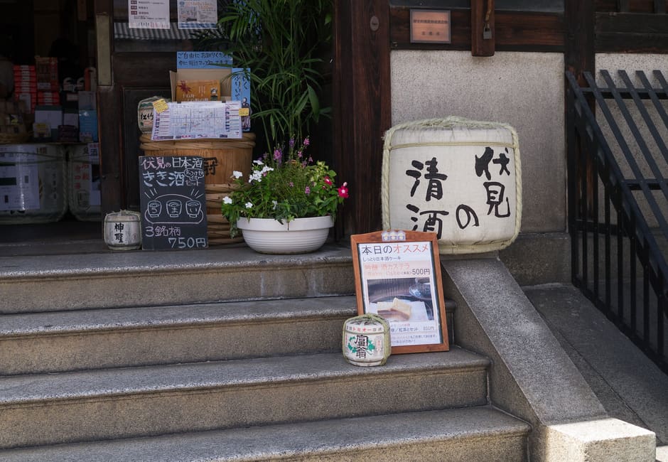 The entrance steps of Fushimi Yume Hyakushu, with a Fushimi sake barrel and boards for its sake tasting set