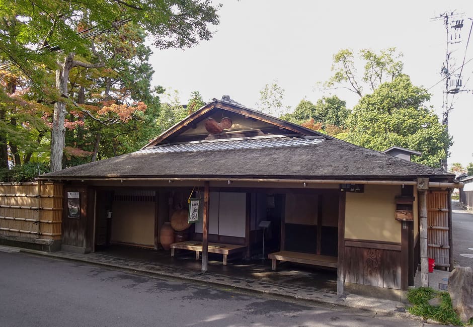 The old tea house front of Hyotei near Nanzen-ji, with wooden benches under its eaves and a gourd on the gable
