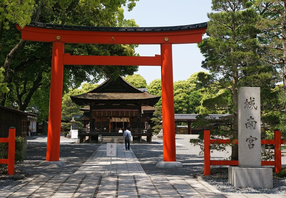 The red torii and stone name pillar of Jonangu, with the shrine gate at the end of the paved approach