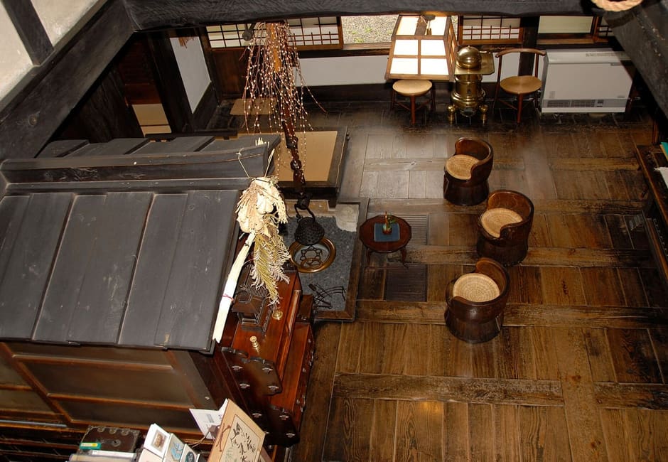 The wooden main hall of Kawai Kanjiro's House with its hearth and carved chairs, Kyoto