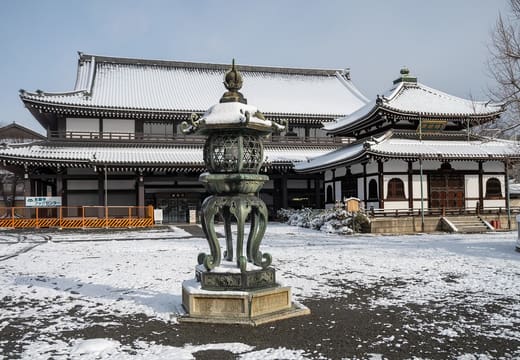 The great wooden halls of Nishi Hongan-ji after a snowfall, with a bronze lantern