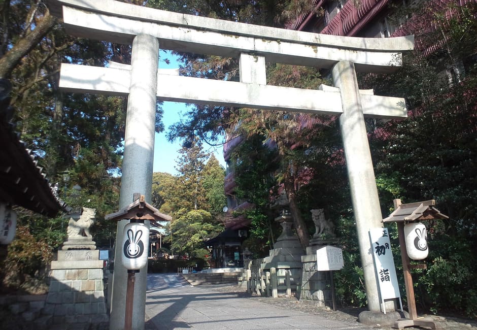 The stone torii at the entrance of Okazaki Shrine, flanked by lanterns painted with rabbits