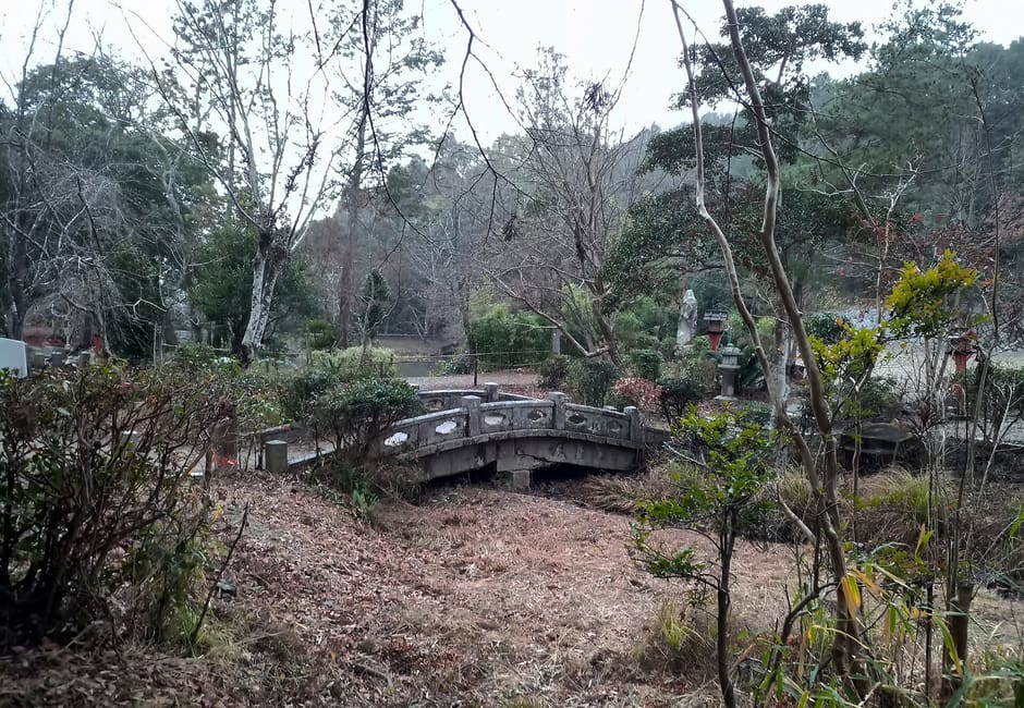 A small stone bridge on the Omuro 88 pilgrimage trail among trees behind Ninna-ji in Kyoto