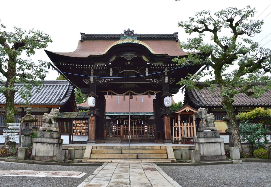 The ornate karamon gate of Rokusonno Shrine with stone steps and guardian lions in front
