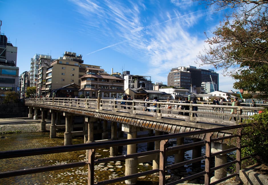 Sanjo Ohashi's wooden railings and piers crossing the Kamo River under a blue autumn sky