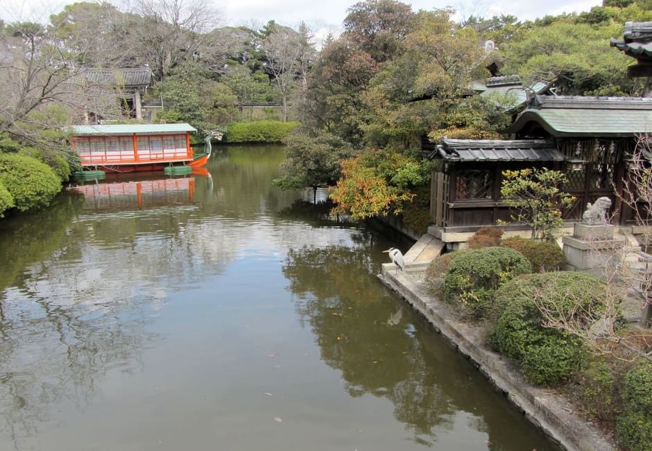 The pond of Shinsen-en garden with its vermilion boat pavilion