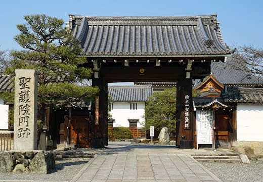 The main gate of Shogo-in temple with its carved stone name pillar and a pine tree beside it