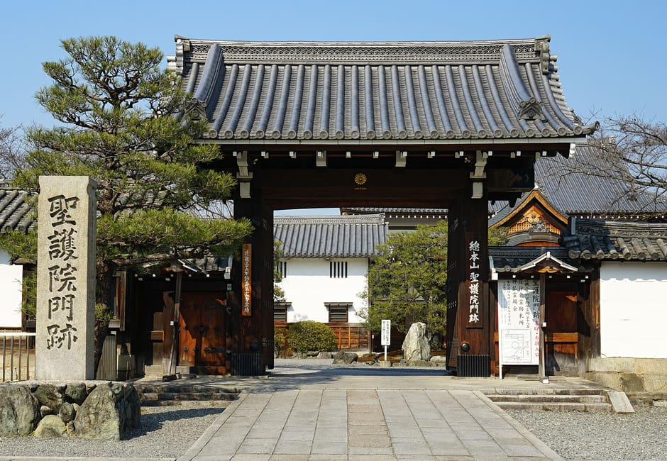 The main gate of Shogo-in temple with its carved stone name pillar and a pine tree beside it