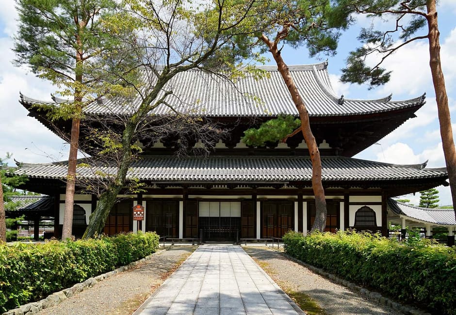 The Dharma Hall of Shokoku-ji at the end of a paved path lined with pines