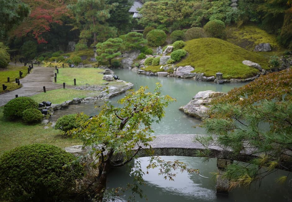 The pond garden of Shoren-in with a small stone bridge and clipped shrubs