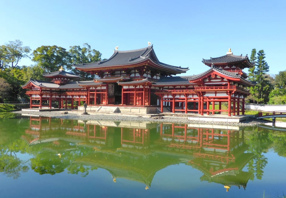 The Phoenix Hall of Byodo-in in Uji reflected in its pond under a clear blue sky
