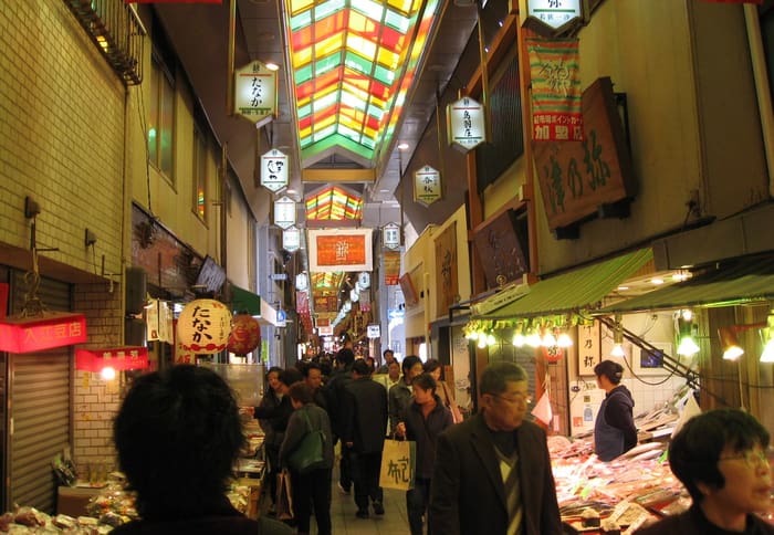 Shoppers under the colourful glass roof of the Nishiki Market arcade
